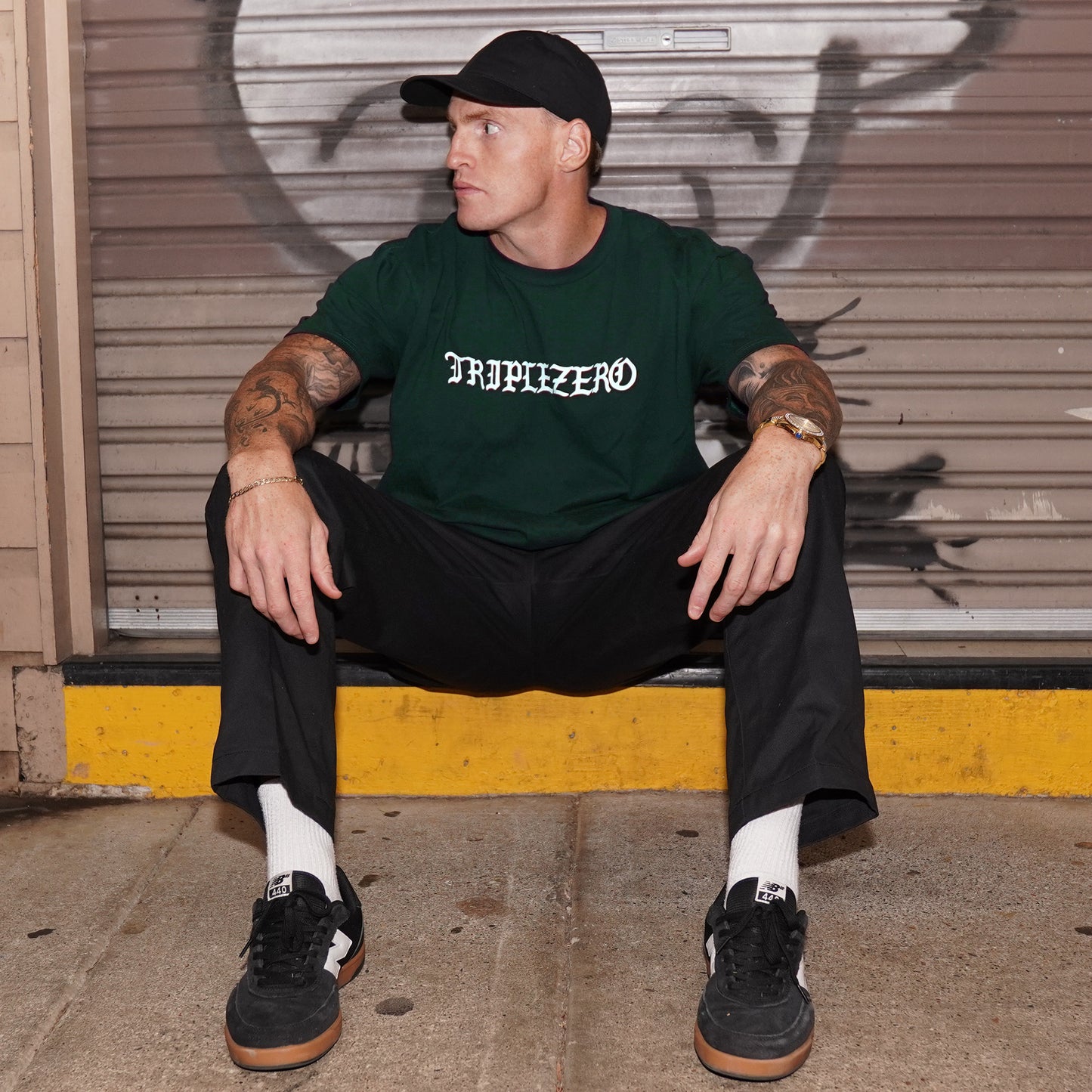 Model wearing a pine green tshirt with a white print